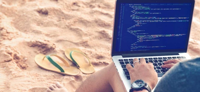 Ein Programmierer Tippen Quellcodes am Strand in einer entspannten Arbeitsumgebung. Studieren, Arbeiten, Technologie, Freelance Work Konzept.