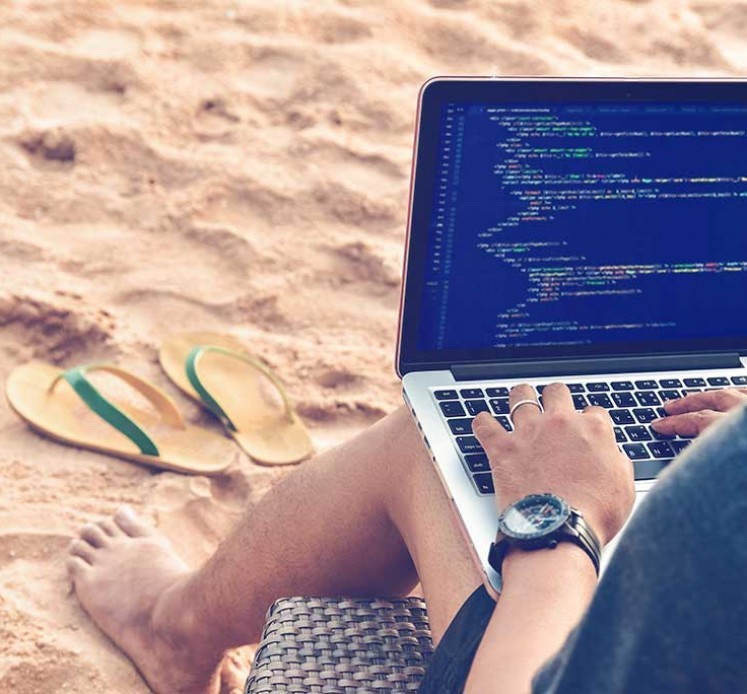 Ein Programmierer Tippen Quellcodes am Strand in einer entspannten Arbeitsumgebung. Studieren, Arbeiten, Technologie, Freelance Work Konzept.