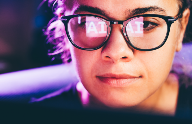 Eine Frau mit Brille nutzt die Technologie der künstlichen Intelligenz auf einem Laptop mit Brillenreflexion.
